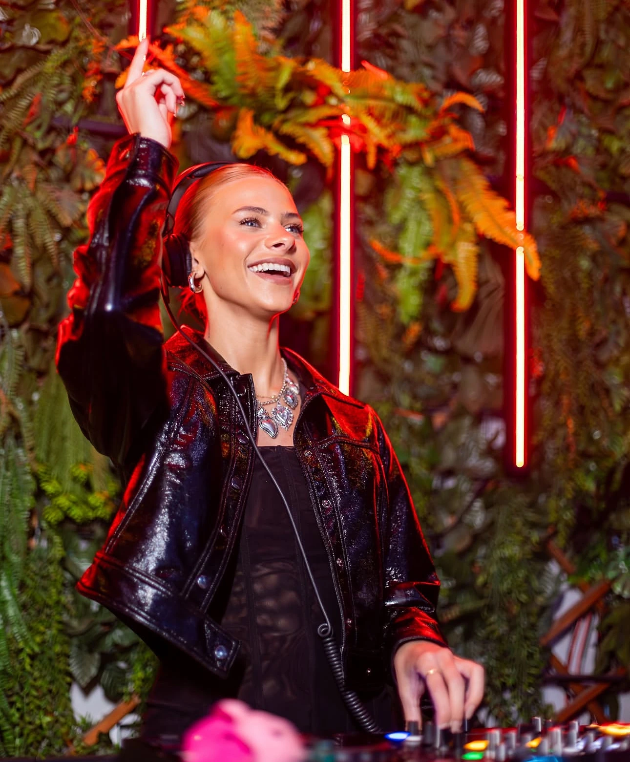 DJ com linhas de LED vermelhas ao fundo